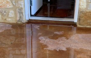 flood in home. Water seeping out of doorway onto concreate.