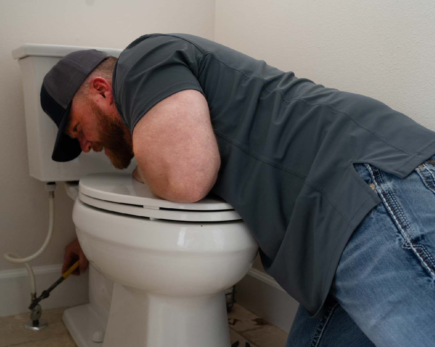 plumber fixing a toilet leak