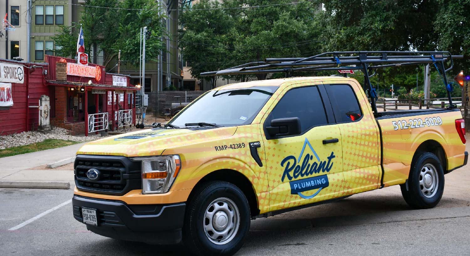 Reliant plumbing branded yellow truck parked in from of "the Ol Spoke" a popular dance hall in south austin